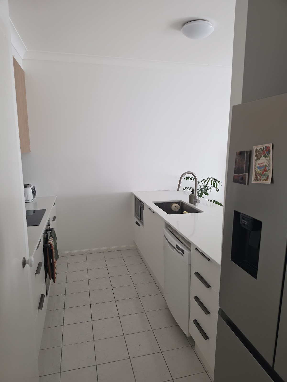 After: the same galley with new white cabinets and an integrated dishwasher