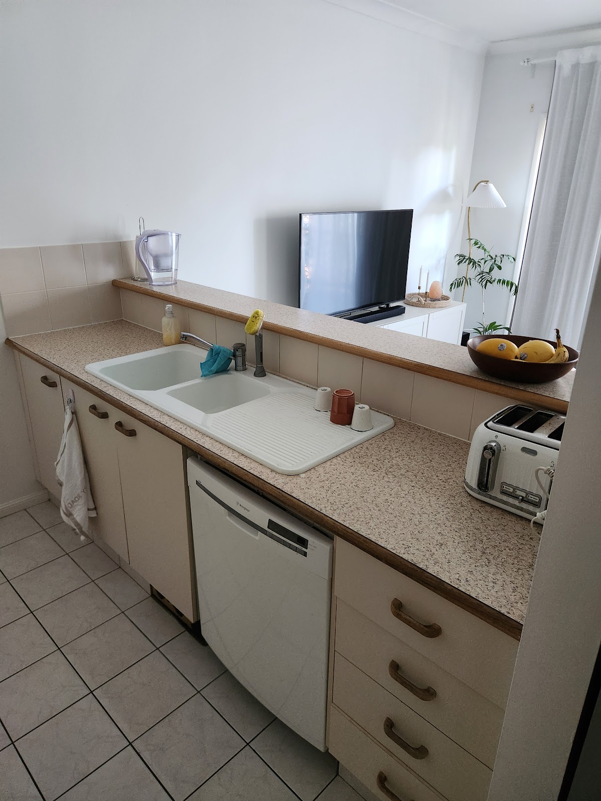 Before: old kitchen with laminate benchtop and a double sink