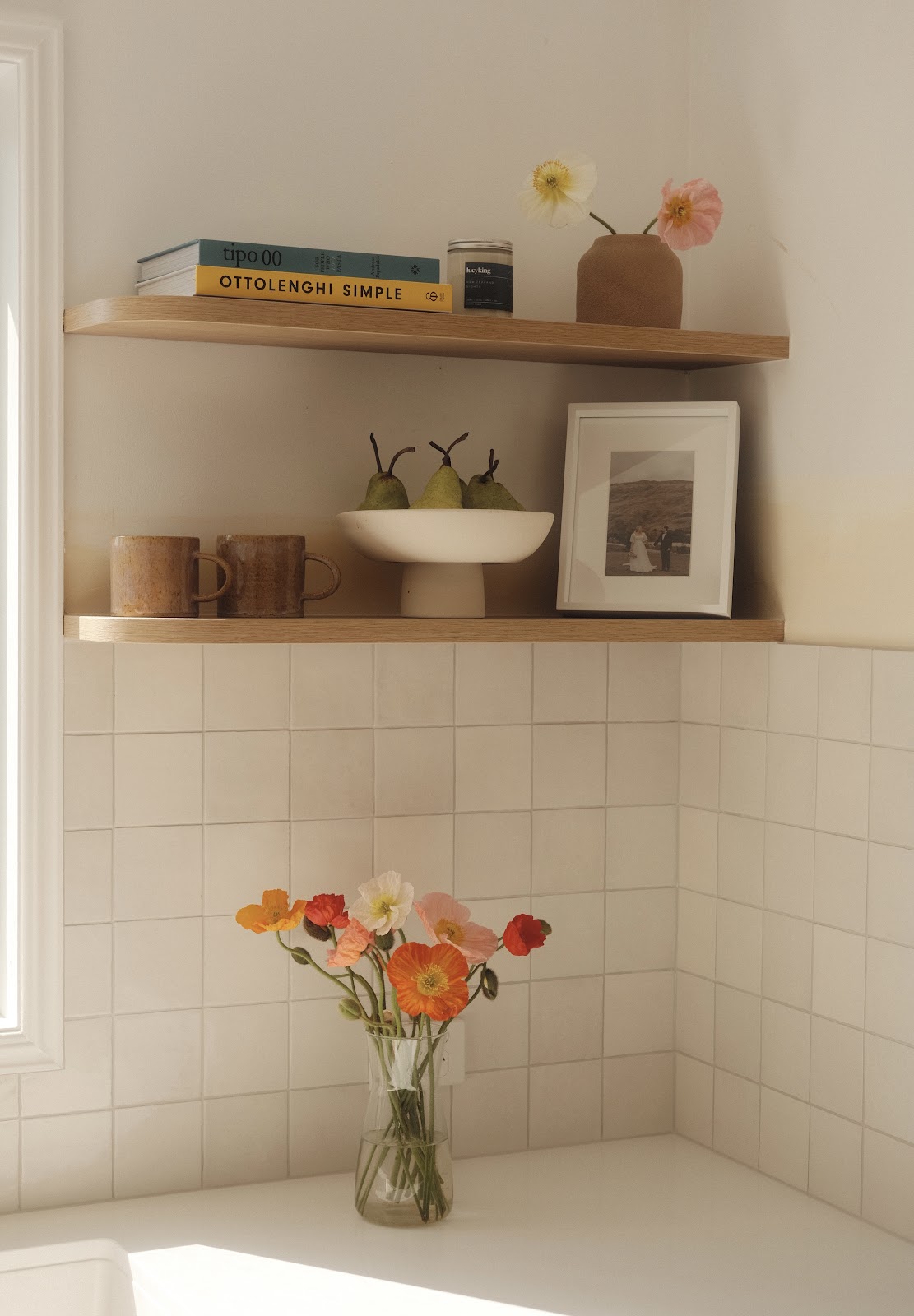 Floating timber shelves above a white tiled splashback